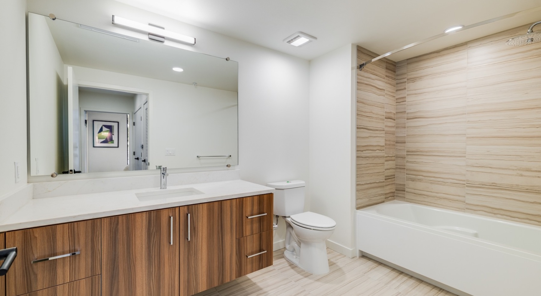 a well-lit bathroom with a large vanity and a tub