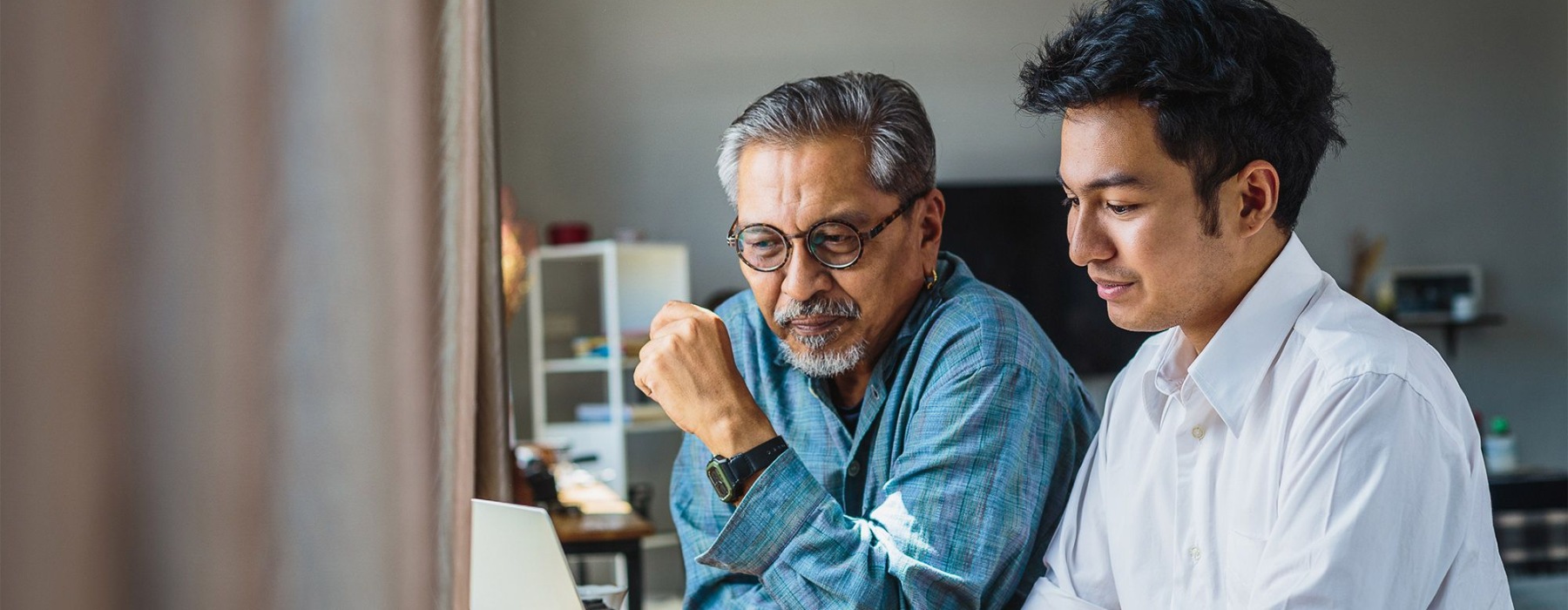 two men looking at a laptop